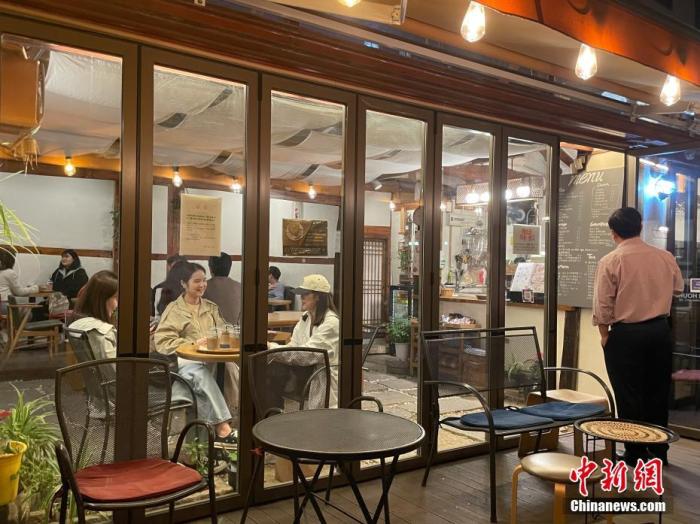 当地时间4月18日,韩国公众聚集场所营业限时以及私人聚会、活动和集会限员等保持社交距离措施全面解除。图为市民当晚在首尔麻浦区一咖啡厅聚会。 <a target='_blank' data-cke-saved-href='http://www.chinanews.com/' href='http://www.chinanews.com/'>中新社</a>记者 刘旭 摄 当地时间4月18日,韩国公众聚集场所营业限时以及私人聚会、活动和集会限员等保持社交距离措施全面解除。图为市民当晚在首尔麻浦区一咖啡厅聚会。 <a target='_blank' data-cke-saved-href='http://www.chinanews.com/' href='http://www.chinanews.com/'>中新社</a>记者 刘旭 摄