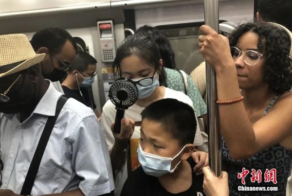 当地时间7月19日,法国首都巴黎气温突破40摄氏度。当天仍有不少民众选择乘坐地铁出行。图为在拥挤的巴黎地铁车厢内,有民众用微型风扇解暑。中新社记者 李洋 摄 当地时间7月19日,法国首都巴黎气温突破40摄氏度。当天仍有不少民众选择乘坐地铁出行。图为在拥挤的巴黎地铁车厢内,有民众用微型风扇解暑。中新社记者 李洋 摄