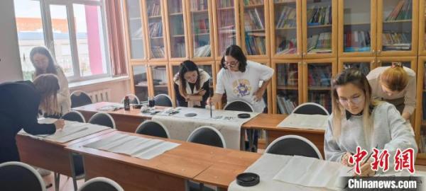 汉语学习爱好者进行书法写作。 卡拉干达萨金诺夫技术大学孔院供图 汉语学习爱好者进行书法写作。 卡拉干达萨金诺夫技术大学孔院供图